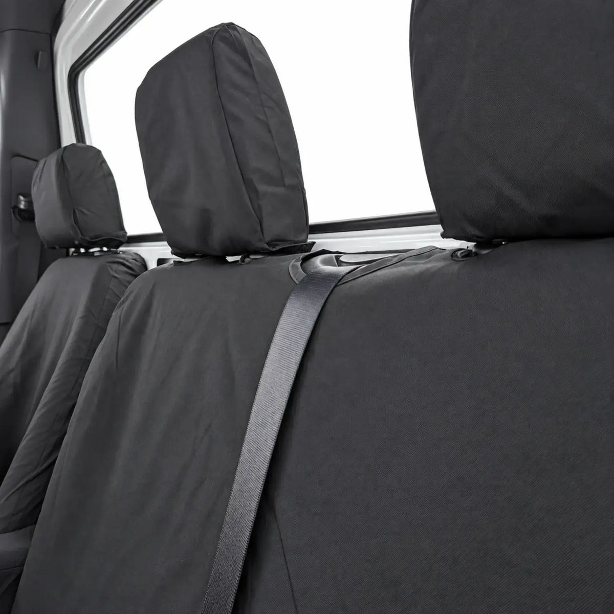 Close-up of black bench seat covers with headrest covers and seat belt access