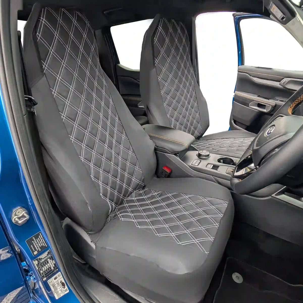 Black diamond-patterned car seat covers in a vehicle interior.