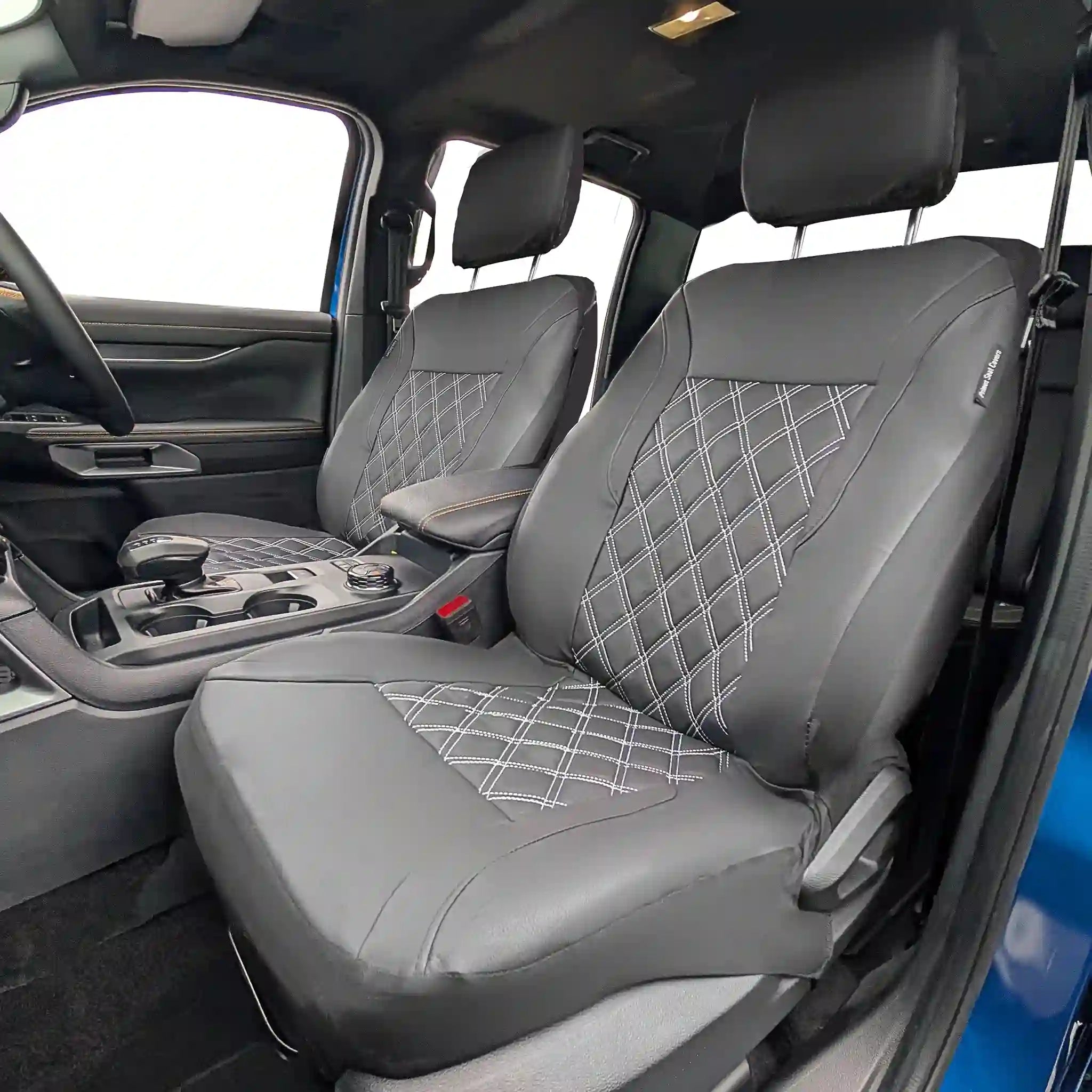 Black car seat covers with diamond pattern in a vehicle interior