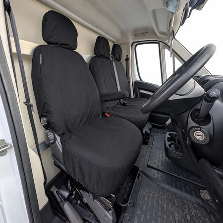 Black fixed-base seat covers with headrests for front seats in a van