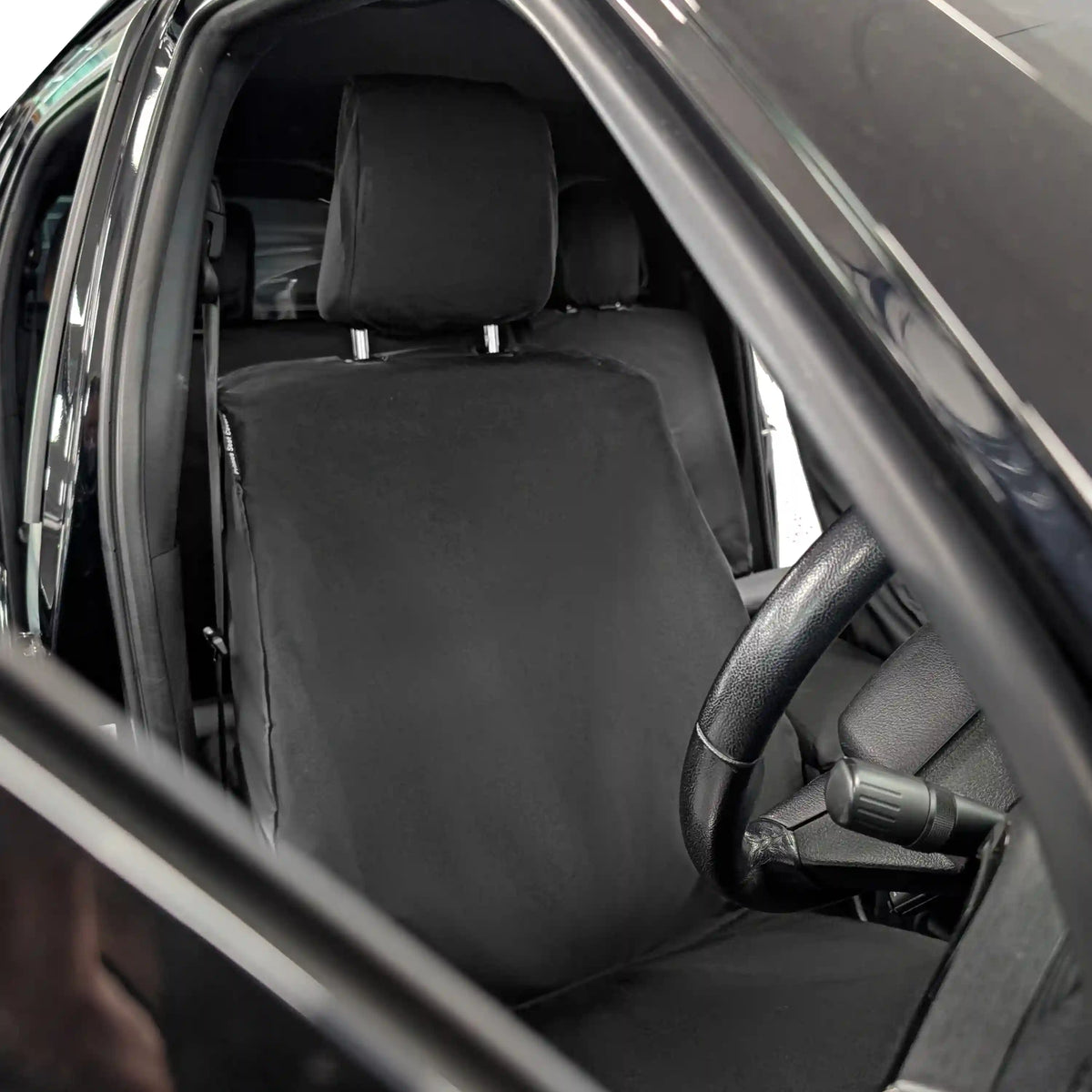 Black car seat covers inside a vehicle with open door