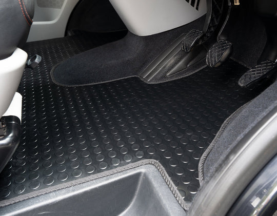 Car interior with black floor mats covering the floor.